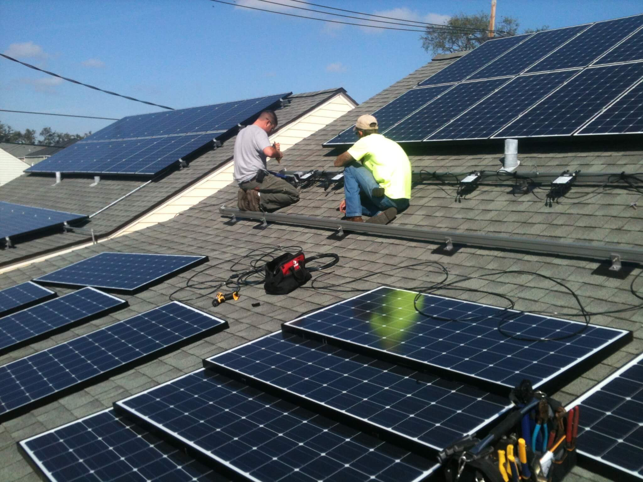 Installers working on solar panels on a residential rooftop