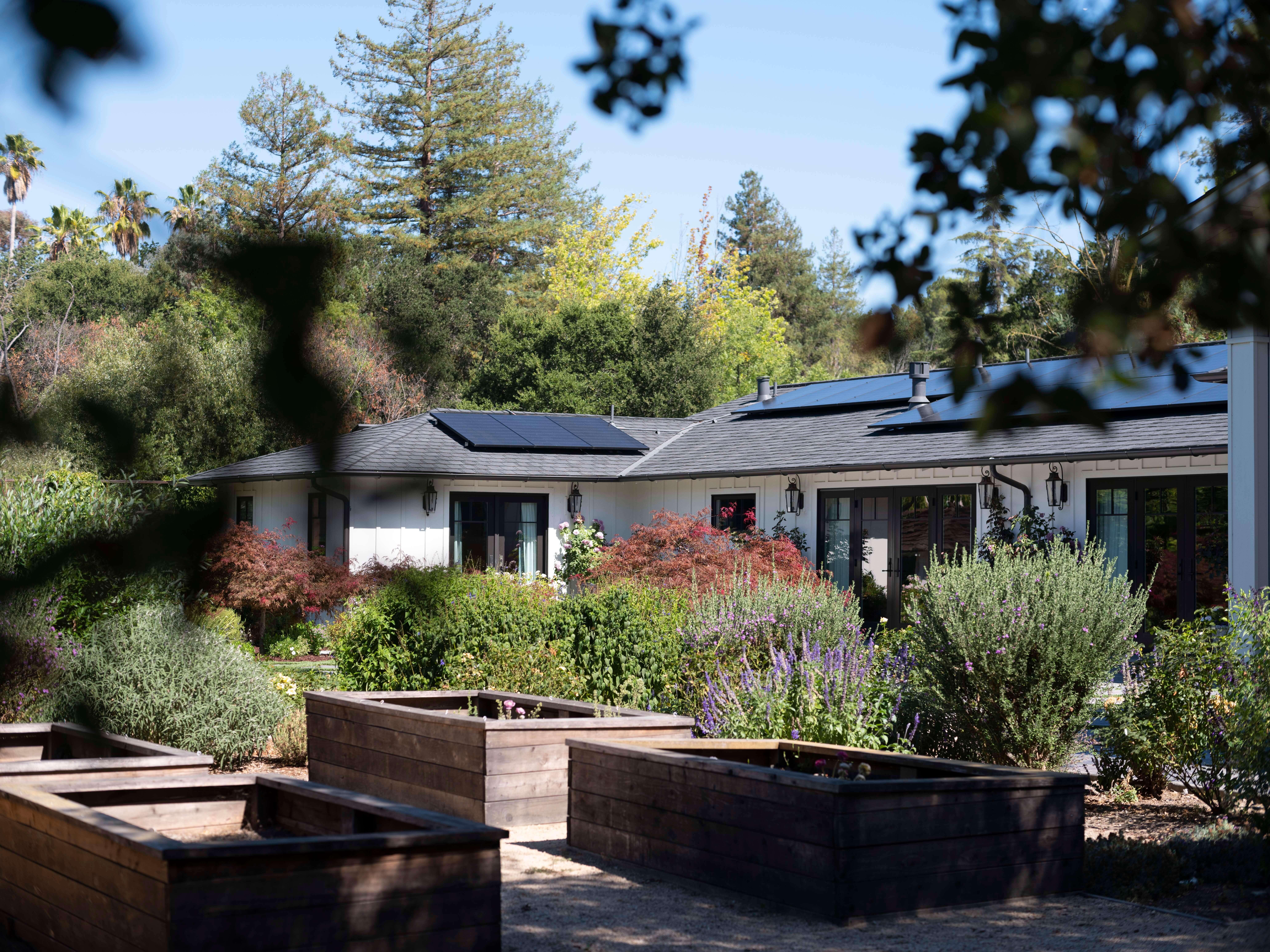 Charming house with rooftop solar panels in a green setting